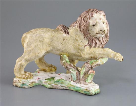A rare and early English porcelain figure of a lion, possibly Bow, c.1750, L. 20cm, repairs and black speckling to the glaze